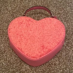 A pink fuzzy Kate Spade heart bag